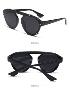Detail view of black oversized geometric sunglasses with decorative gold metal rivets