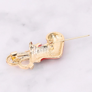 Detail shot of the gold Christmas stocking brooch back showing pin clasp and red enamel