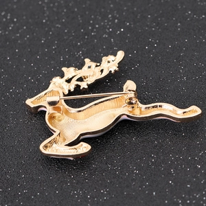 Close-up of a golden reindeer brooch with a detailed metal texture on a black background