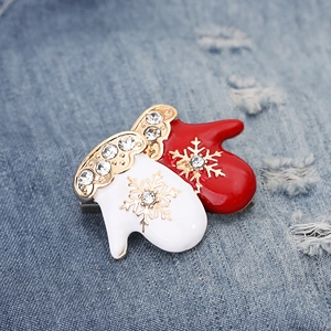 Detailed macro view of red and white enamel Christmas glove brooches with crystal accents
