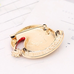 Macro view of gold metal brooch back with pin clasp and red enamel detail highlights