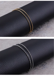Close-up of gold and silver stainless steel O-chains displayed on black leather