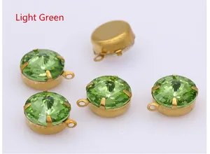 Detailed view of light green faceted glass pendants with gold claw settings and metal backing