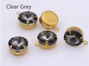 Close-up of transparent gray faceted glass crystals with gold metal claw settings for DIY
