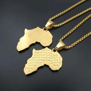 Detail of two gold-plated Africa map pendants with smooth and grid texture finishes