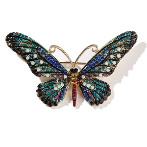 Macro detail of enamel butterfly brooch with colorful rhinestones on gold alloy base