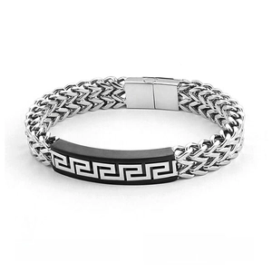Detailed macro view of vintage stainless steel meander pattern on a double-layer chain bracelet