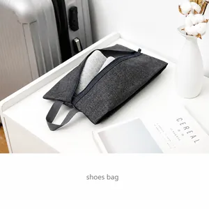 Close-up of a dark grey oxford shoe bag with center zipper and carrying handle