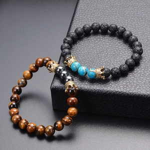 Detailed shot of lava stone and tiger eye bracelets with zircon crowns on leather box