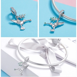 Detail of S925 silver hummingbird charm with green gemstone olive branch and pavé crystals