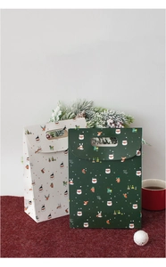 Detail of Christmas gift bags with Santa Claus prints and festive paper handle cutouts
