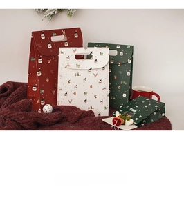 Christmas gift bags with festive prints on warm red blanket with holiday decor