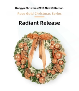 Close-up of rose gold Christmas wreath with flocked pine needles and decorative baubles