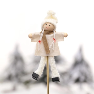 Miniature Christmas snowman doll with white knit hat and beige dress on a metal stand