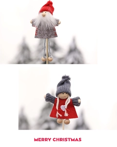 Detailed view of handmade plush Santa and girl figurines with knit hats on wooden sticks