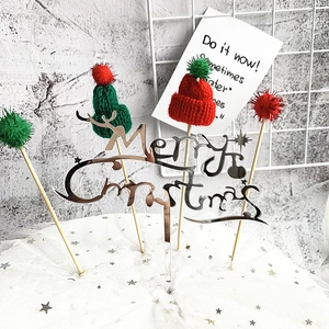 Close-up of silver acrylic Merry Christmas cake topper and mini knitted hats set