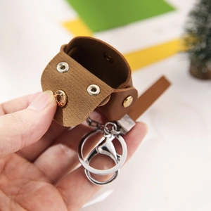 Brown leather mini storage pouch with snap buttons and metal keychain hook