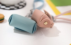 Detailed view of mini PU leather coin purses in light blue and pink with gold hardware