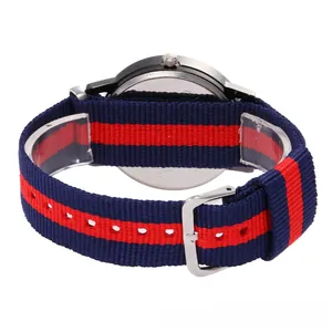 Detail of red and blue striped nylon watch strap with silver buckle and steel back