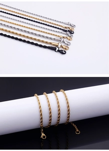 Close-up of twisted rope necklaces in gold, silver, and black stainless steel