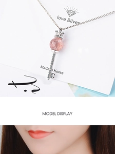 Detail of silver crown key necklace with pink stone and zircon on display card