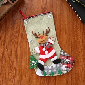 Close-up of linen Christmas stocking with 3D reindeer doll and red plaid cuff details