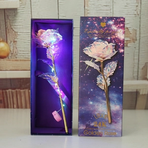 Detailed view of an illuminated 24k gold foil rose with LED lights inside a purple gift box