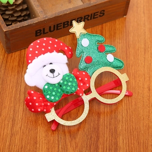 Detail of Christmas tree and teddy bear decorations on festive red party glasses