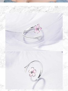 Detail of silver adjustable ring with a pink flower and crystal on soft feathers