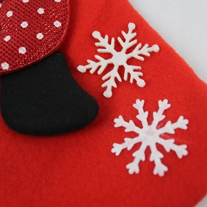 Close-up of red felt Christmas stocking featuring white snowflake patterns and texture