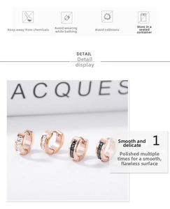 Detail view of rose gold steel hoop earrings with black and white zircon stone inlays