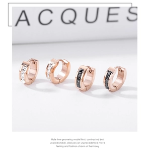 Detailed macro view of rose gold hoop earrings with black and white square-cut zircons