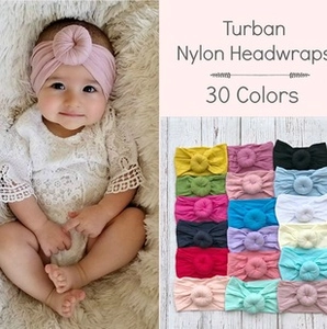 Selection of colorful nylon baby headwraps in various shades and a model wearing pink turban