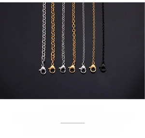 Macro detail of stainless steel link chains with lobster clasps in silver gold and black