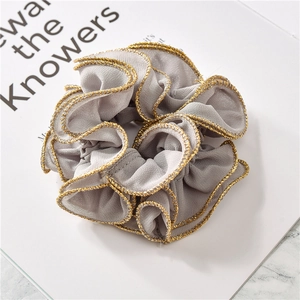 Close-up of grey chiffon scrunchie with lettuce edge and metallic gold trim details