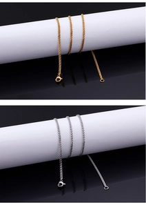 Detailed view of gold and silver cuban chain necklaces with lobster clasp on cylinders