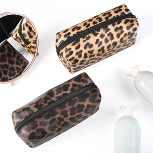 Detailed top view of leopard print cosmetic bags with black zipper in a beauty setup