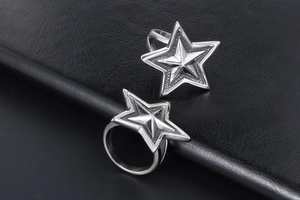 Macro detail of two punk silver titanium steel rings with sculpted five-point star design