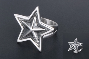 Macro shot of silver titanium steel star ring with detailed metallic texture and shine