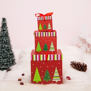 Dreiteiliges rotes Weihnachtsgeschenkbox-Set mit Sternmuster auf weißem Fellteppich