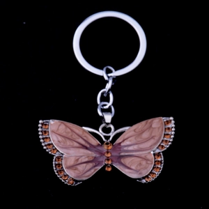 Detail of butterfly keychain with brown marble texture wings and brown rhinestone edges