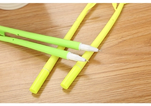 Close-up of three creative camellia gel pens with green stems on a wooden table
