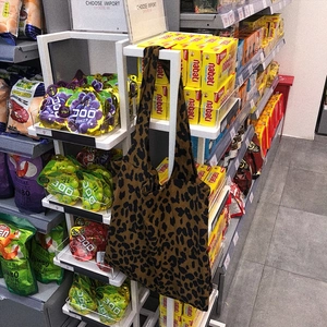Detail of leopard print canvas shoulder bag texture hanging in a retail display
