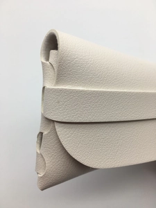Detail of white lychee grain leather glasses case showing the strap closure mechanism