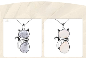 Detail of cute cat pendants with white marble and pink gemstones in silver frames