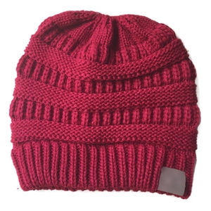 Close-up of dark red chunky knit beanie featuring ribbed texture and woven patterns
