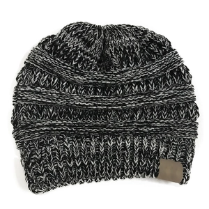 Detail of grey knitted ponytail beanie with horizontal stripes and brown leather patch