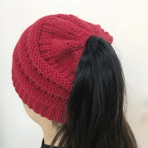 Detail of chunky knit ponytail beanie in dark red showing the rear opening for hair