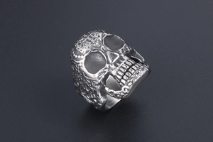 Detailed macro view of retro skull ring with intricate gothic floral engravings and silver finish