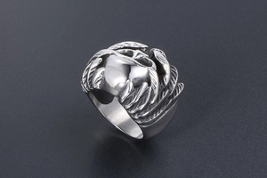 Detailed close-up of retro silver stainless steel ring with gothic wing and skull carvings